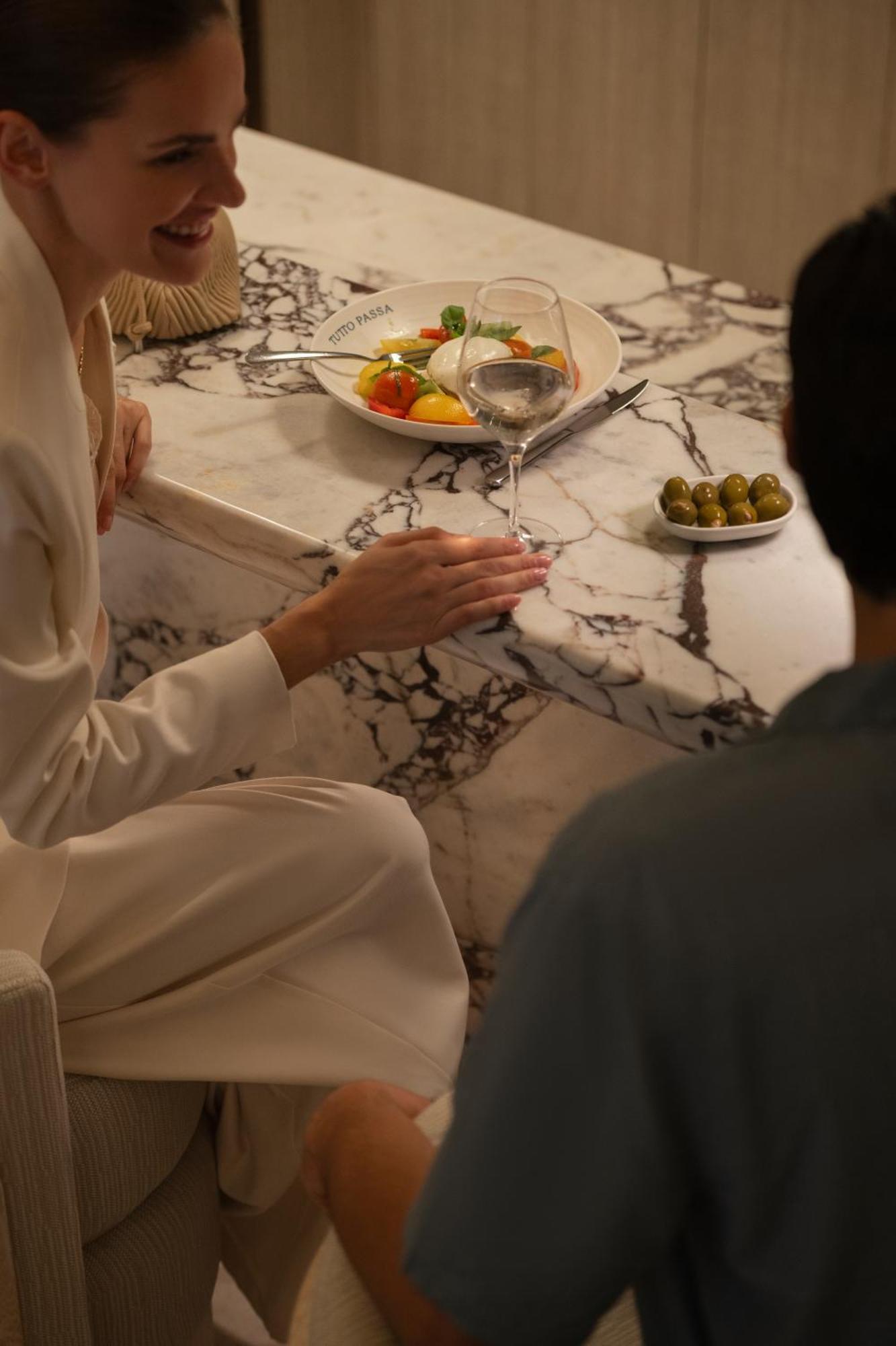 ホテル シーザーズ パレス ブルーウォーターズ ドバイ エクステリア 写真 A woman holding a wine glass